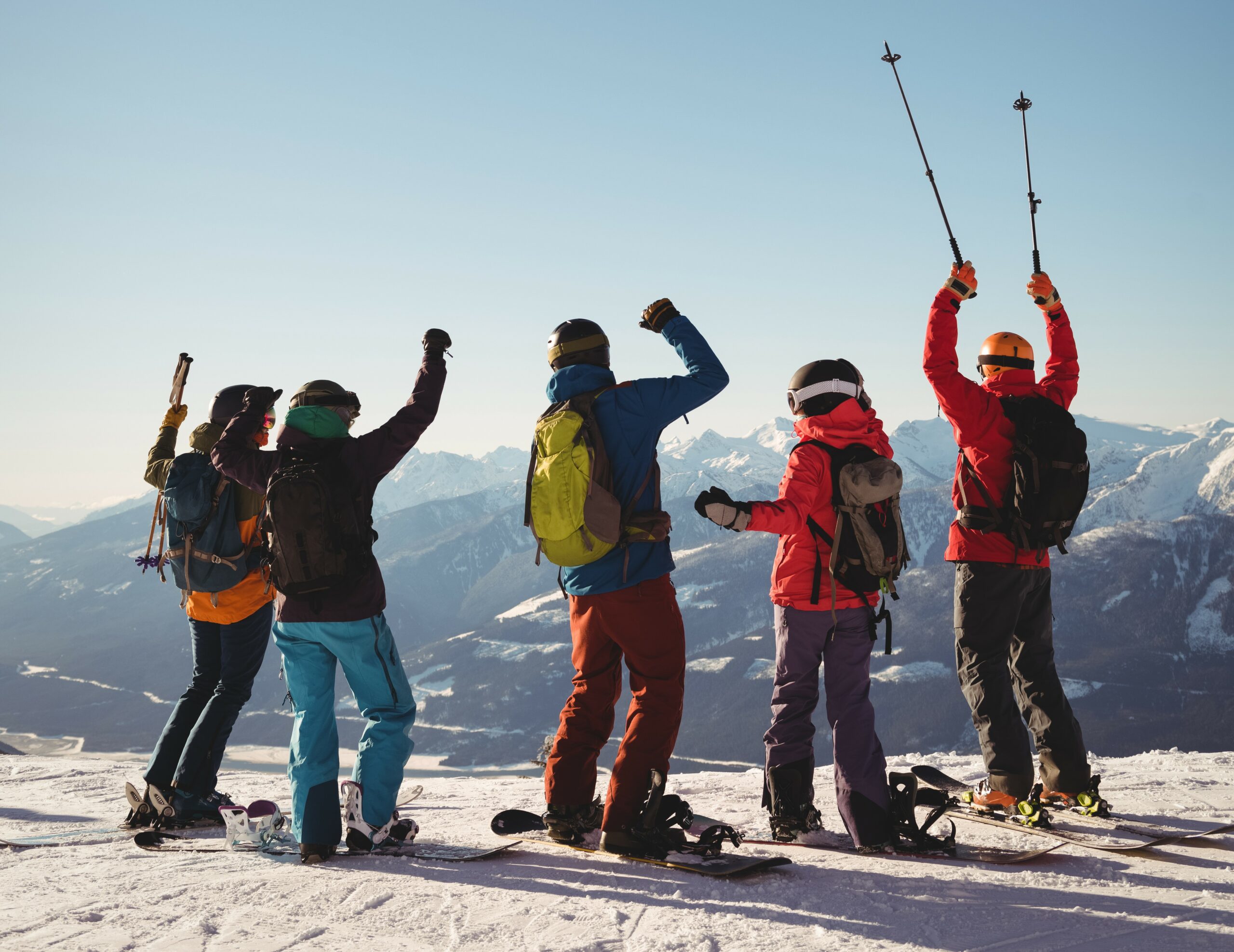 Celebrating skiers standing on snow covered mountain